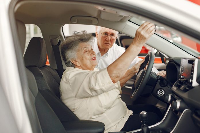Elegant old couple in a car salon